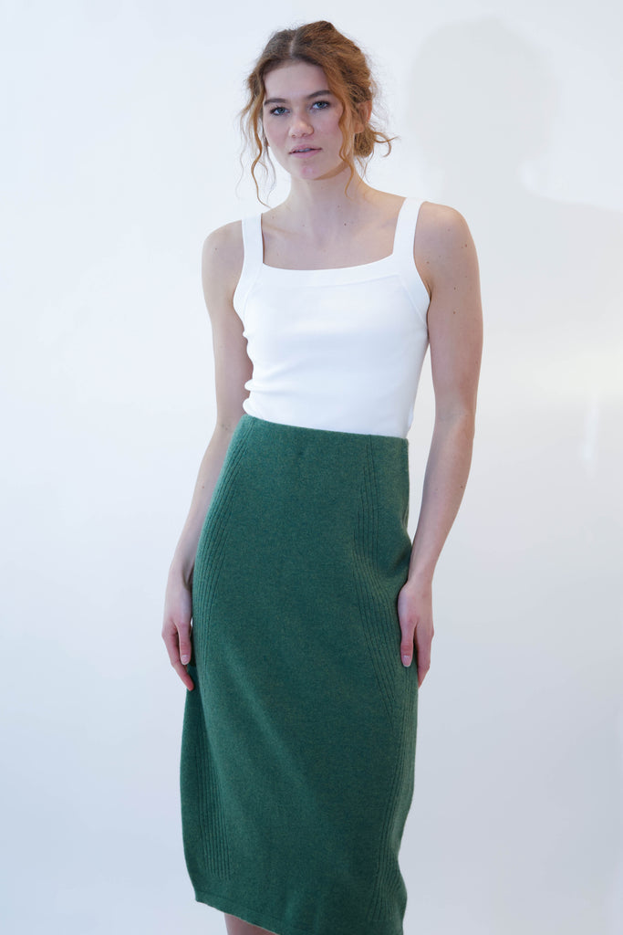 Model wearing alicia green midi skirt on white background