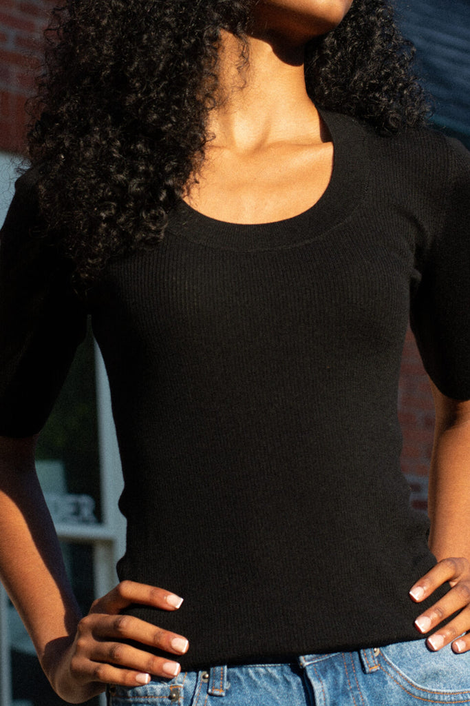 Close up of model wearing the ami black top