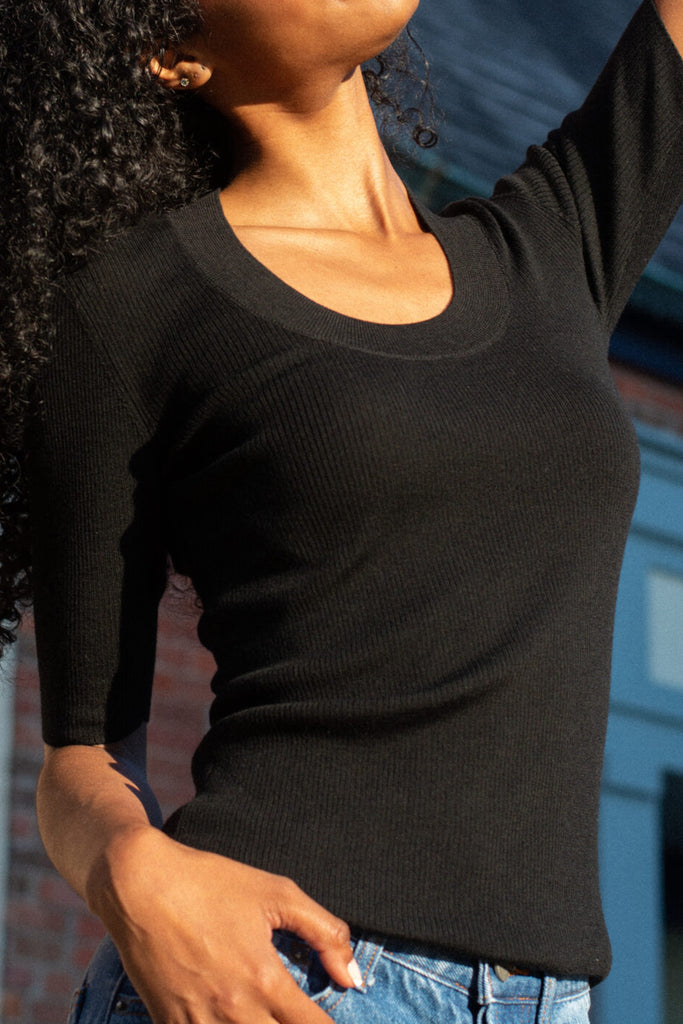 Close up of model posing while wearing ami top