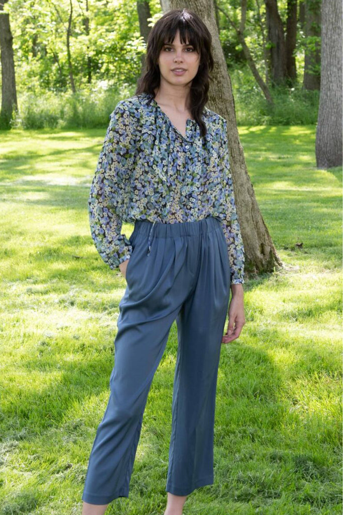 Model posing outdoors with the Alora floral blouse 
