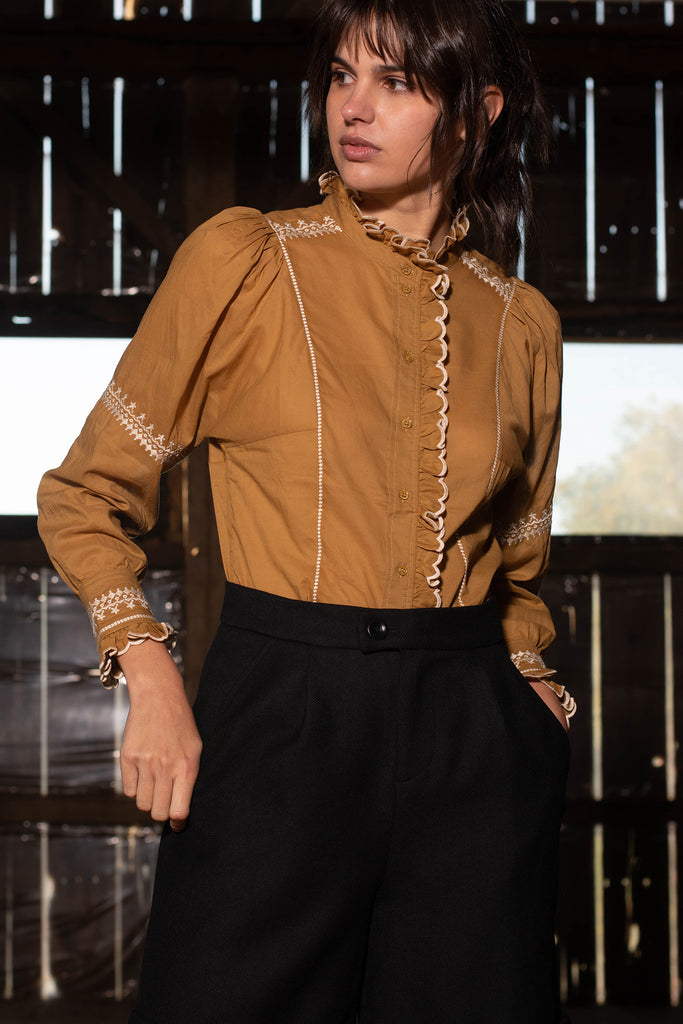 Woman wearing ecru Auriane blouse in barn