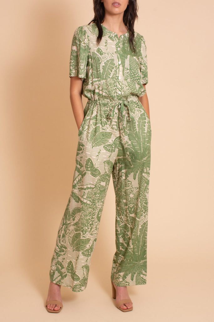 Woman wearing Sage tropical print jumpsuit