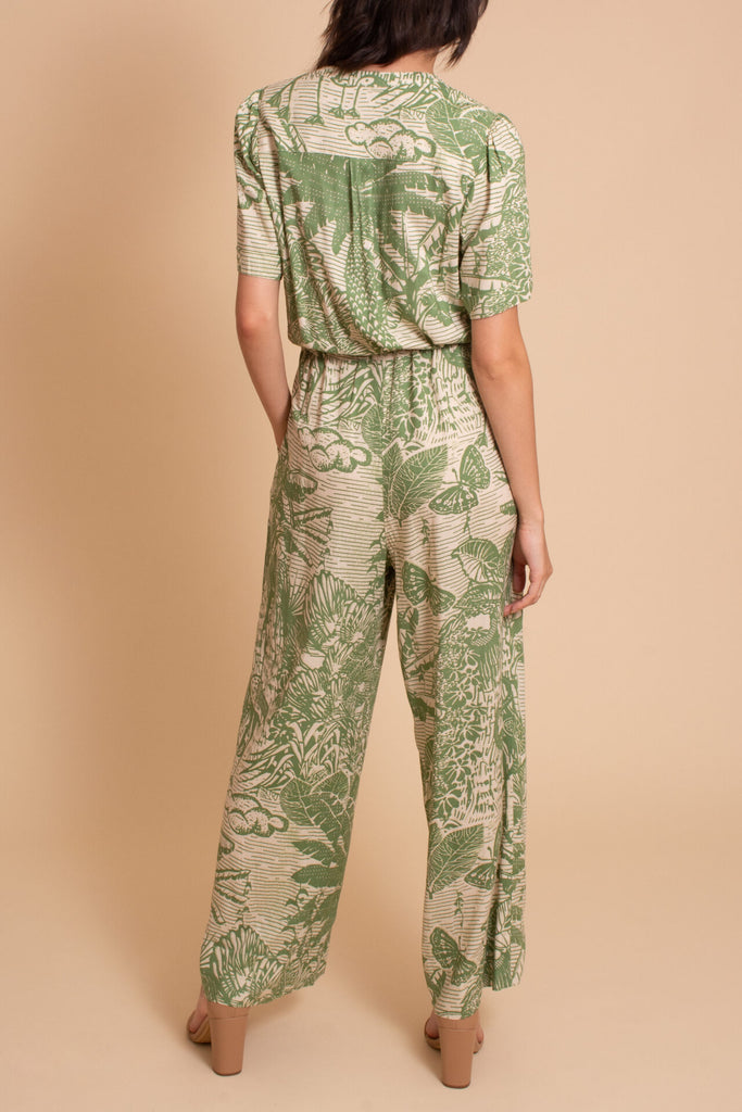Woman wearing Sage tropical print jumpsuit